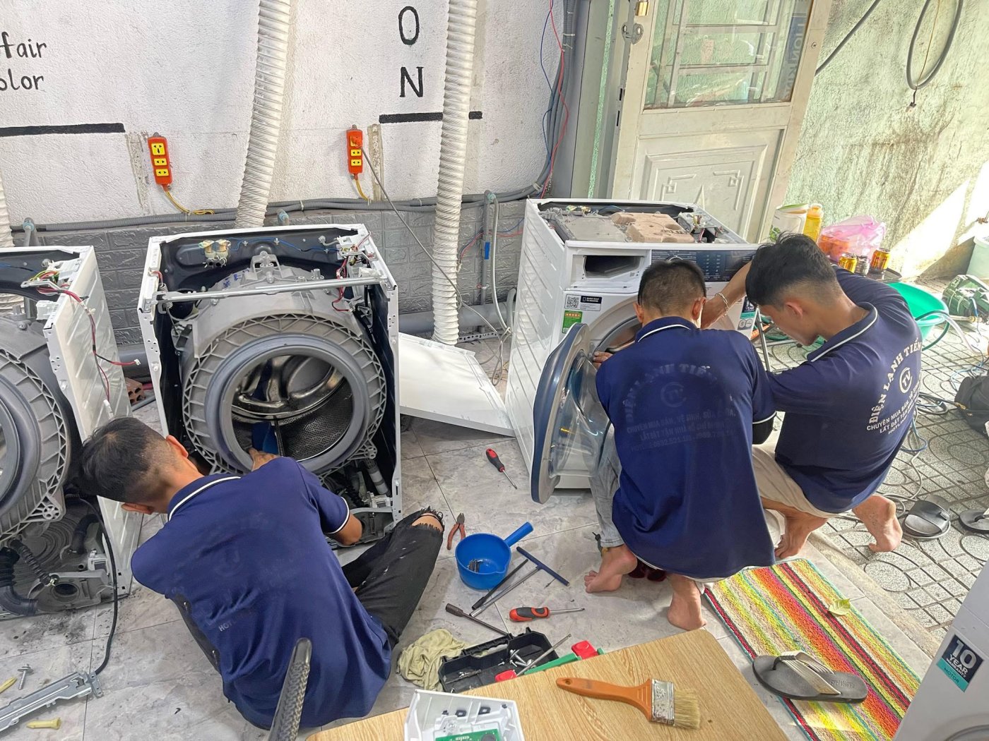 các kỹ thuật viên đang sửa chữa và bảo dưỡng, vệ sinh máy giặt tận nơi ở Buôn Ma Thuột